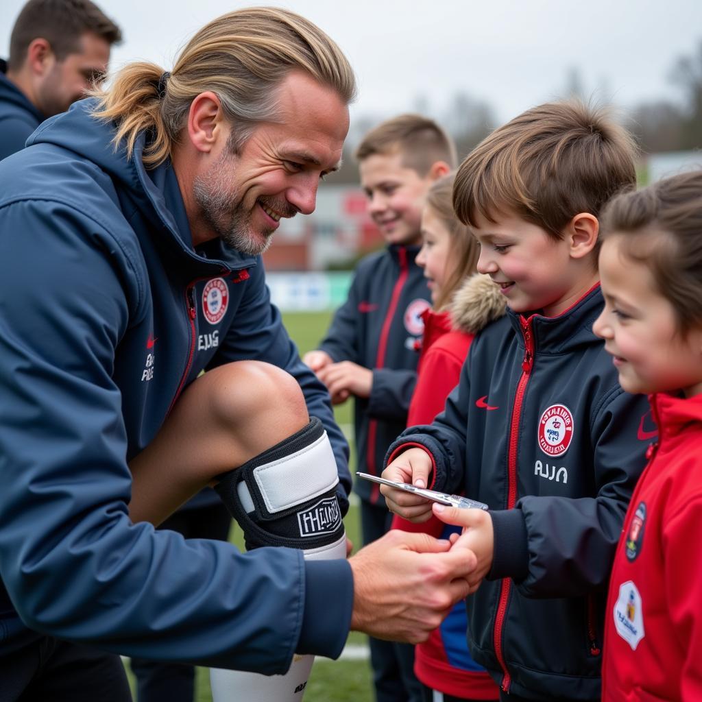 Erling Haaland signing autographs for fans at the training ground