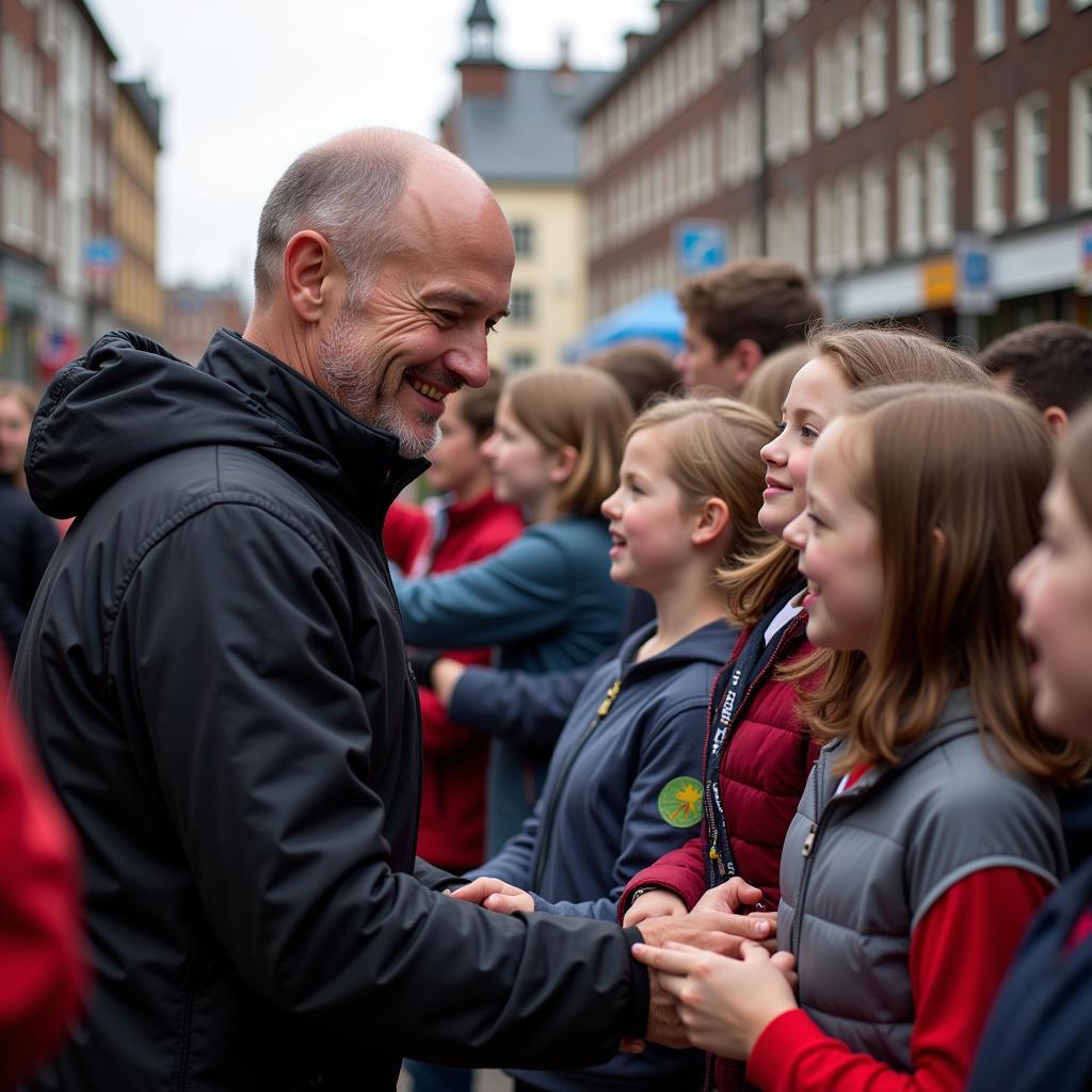 Erling Haaland interacts with young fans at a community event, smiling warmly.